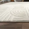 A close-up view of a cream-colored rug with a geometric pattern on a wooden floor. Anteprima dell’immagine prodotto