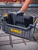 A person's hand wearing a glove is holding a black DeWalt toolbox over a grid of rebar on a concrete surface. Podgląd zdjęcia produktu