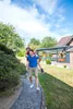 Two men are playing in a garden, one giving the other a piggyback ride. Produktbild-Vorschau