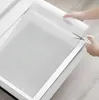 A person is cutting a roll of anti-slip drawer liner with scissors to fit into a drawer. Voir les images du produit