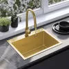 A gold sink and faucet are shown in a kitchen setting with plants and dishes. Podgląd zdjęcia produktu