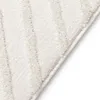 A close-up view of a white rug with a subtle diamond pattern. Anteprima dell’immagine prodotto