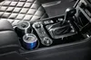 The interior of a car, focusing on the center console with two travel mugs in the cup holders. Anteprima dell’immagine prodotto