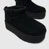 A close-up shot of black platform UGG boots. Voir les images du produit