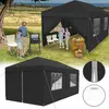 A family is enjoying a picnic under a black canopy tent in a grassy outdoor setting with a barbecue grill and picnic table. Produktbild-Vorschau