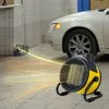 A yellow and black industrial fan heater is shown in a garage or workshop setting, with a white car in the background and heat waves emanating from the heater. Produktbild-Vorschau