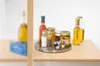 A rotating tray with various jars and bottles of food items on a wooden surface. Anteprima dell’immagine prodotto
