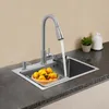A kitchen sink with a faucet running water into it, a basket of oranges, and a soap dispenser. Podgląd zdjęcia produktu