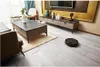 A modern living room with furniture and a robot vacuum cleaner. Podgląd zdjęcia produktu