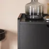 A close-up view of a black shoe cabinet with decorative items on top. Produktbild-Vorschau