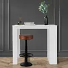 A white bar table with a brown stool in front of it, set against a dark gray wall with wood flooring. Produktbild-Vorschau