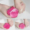 Leuchtend rosa Silikon-Gesichtsreinigungsbürste wird verwendet, um Make-up von einer Hand in einem weißen Waschbecken zu waschen, in einer vierteiligen Collage Anteprima dell’immagine prodotto