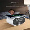 A person sleeping in bed with a wireless charging alarm clock on a nightstand. Produktbild-Vorschau