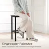 A person is sitting on a bar stool next to a bar table, demonstrating the footrest. Anteprima dell’immagine prodotto
