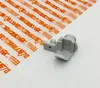 A gray plastic part is placed on a white surface next to a sheet of transparent plastic with orange text. Produktbild-Vorschau