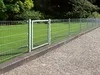 A metal fence with a gate in a garden setting. Produktbild-Vorschau