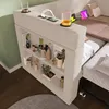 A modern sofa bed with integrated shelving and charging ports, set up in a room with a green wall and wooden floor. Anteprima dell’immagine prodotto