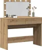 A vanity table with a mirror and lights, decorated with some items. Voir les images du produit