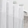 Close-up view of white sheer curtains hanging from a track. Podgląd zdjęcia produktu