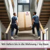 Two movers carrying a large cardboard box up a staircase. Produktbild-Vorschau