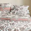A close-up view of a bed with a paisley-patterned duvet and pillows. Produktbild-Vorschau