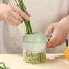A person is using a portable electric vegetable chopper to chop green onions. Náhled obrázku produktu