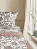 A close-up view of a bed with patterned bedding and a curtain in the background. Produktbild-Vorschau