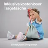 A young child sits on the floor holding a small drawstring bag. Anteprima dell’immagine prodotto