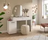 A well-lit room with a white vanity table, a round mirror, and decorative items. Produktbild-Vorschau