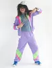 A person wearing a retro tracksuit and wig poses against a white background. Produktbild-Vorschau