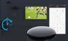 A smart remote device is shown in the foreground, with a television displaying a soccer game in the background. A smartphone screen displaying a remote control interface is also visible. Produktbild-Vorschau