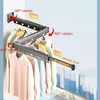 A wall-mounted retractable clothes rack with clothes hanging on it, shown against a backdrop of a city skyline. Produktbild-Vorschau