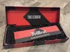 An open box containing a product, with shredded black paper filler. Produktbild-Vorschau