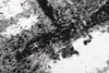 A close-up view of a rug with a modern abstract pattern in black, gray, and white. Produktbild-Vorschau