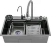 A stainless steel kitchen sink with multiple features, including a faucet, a smaller basin, a drainer tray, and a cup rinser. Náhled obrázku produktu