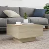 A coffee table in a living room setting, placed on a rug in front of a sofa. Náhľad obrázku produktu