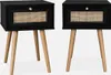 Two black nightstands with wooden legs and rattan drawer fronts are shown against a white background.