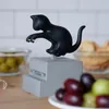 A black cat-shaped toothpick dispenser sits on a kitchen counter next to a bowl of olives and a plate of grapes. Podgląd zdjęcia produktu