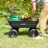 A person is loading a garden cart with a watering can and plants in a garden. Náhled obrázku produktu
