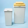 Two laundry baskets are shown against a light blue background. The larger basket has two folded yellow towels on top. Voir les images du produit
