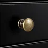 A close-up shot of a black drawer with a bronze knob. Produktbild-Vorschau