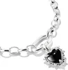 A close-up shot of a silver bracelet with a black heart-shaped charm. Anteprima dell’immagine prodotto