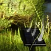 A solar-powered garden light is shown in a grassy outdoor setting. Anteprima dell’immagine prodotto