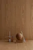 A still life arrangement of cutlery and a wooden sphere on wooden blocks against a wooden background. Produktbild-Vorschau