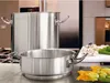 A kitchen scene with two stainless steel pots and some vegetables on a cutting board. Voir les images du produit