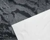 A close-up, flat lay view of a black and silver textured wall panel with a white sheet partially covering it. Anteprima dell’immagine prodotto