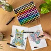 A collection of alcohol markers and coloring pages on a wooden table. Náhľad obrázku produktu