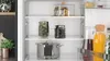 Inside of a refrigerator with food items on shelves. Produktbild-Vorschau