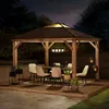 An outdoor gazebo set up for dining at night. Produktbild-Vorschau