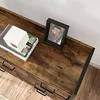 A close-up view of a wooden console table with black metal accents, featuring a stack of books and a framed picture on top. Náhled obrázku produktu